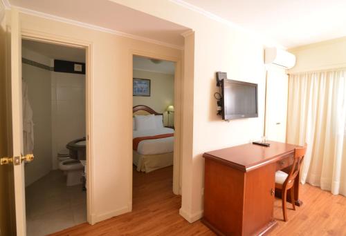 a hotel room with a desk and a bed at Hotel Sunset Beach in Punta del Este