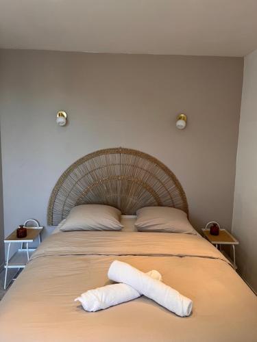 a bed with two white towels on top of it at Le paisible in Oullins