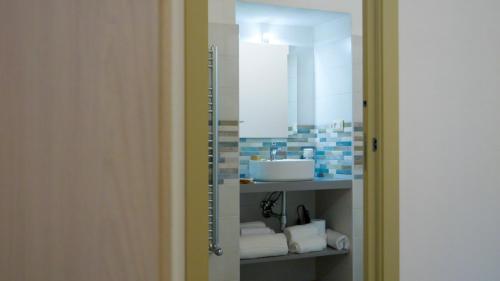 a bathroom with a sink and a mirror and towels at Perla Suite in Mesagne