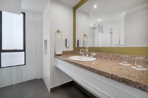 a bathroom with a sink and a large mirror at Hotel Le Manoir Bogotá in Bogotá