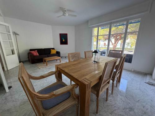 un salon avec une table et des chaises en bois dans l'établissement A071 - Appartement spacieux sur la Croisette, à Cannes