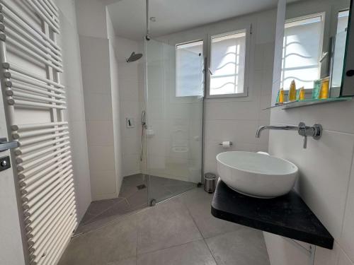 une salle de bain blanche avec un lavabo et une douche dans l'établissement A071 - Appartement spacieux sur la Croisette, à Cannes