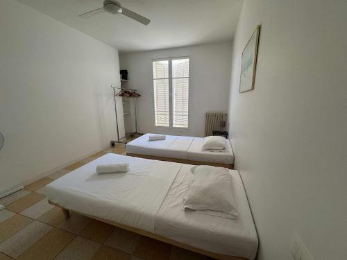 une chambre avec deux lits et une fenêtre dans l'établissement A071 - Appartement spacieux sur la Croisette, à Cannes