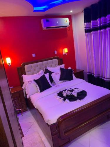 a bedroom with a large bed with red walls at Matcheu Palace Hôtel in Djoungolo
