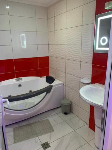 a bathroom with a bath tub and a sink at Matcheu Palace Hôtel in Djoungolo