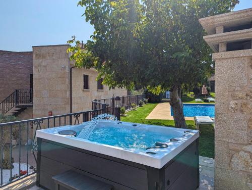 a hot tub on a balcony with a tree at Hotel Apartamento Marouco in A Guarda
