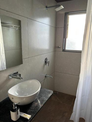 a bathroom with a white sink and a mirror at Sunny Executive in Satara