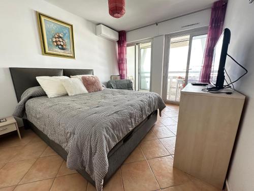 une chambre avec un lit et une télévision sur une commode dans l'établissement Le Clair Horizon-YourHostHelper, à La Grande Motte