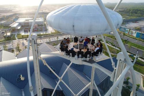 a group of people sitting at tables on a ferris wheel at Umi SplashMania homestay in Banting
