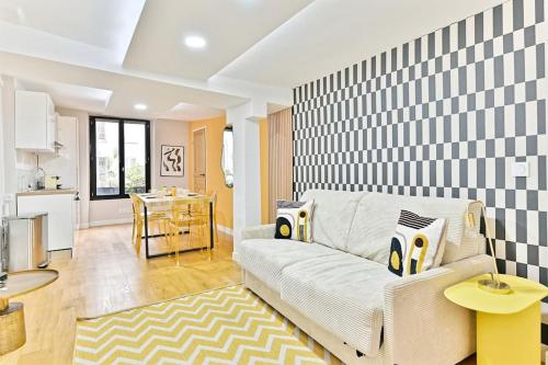 un salon avec un canapé et une cuisine dans l'établissement Appartement 3 chambres Paris 2ème - III, à Paris