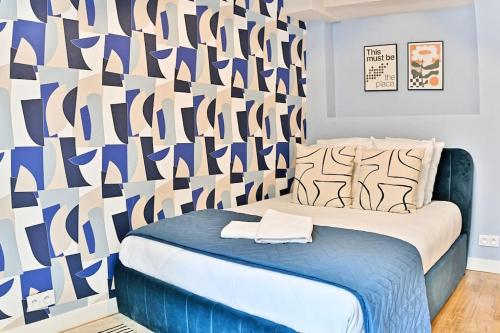 - une chambre avec un lit et un mur avec un motif dans l'établissement Appartement 3 chambres Paris 2ème - III, à Paris