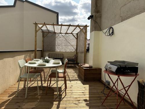 un patio avec une table, des chaises et un barbecue dans l'établissement Voie des Sacres - Cathédrale de Reims, à Reims