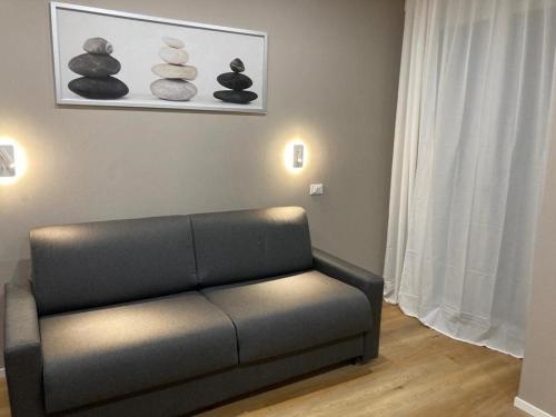 a living room with a couch and some rocks on the wall at Monolocale nuovo arredato vista mare in Valverde