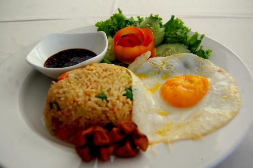 Hotel Dhyana Pura في Kapal: طبق من الطعام مع بيض مقلي وخضروات