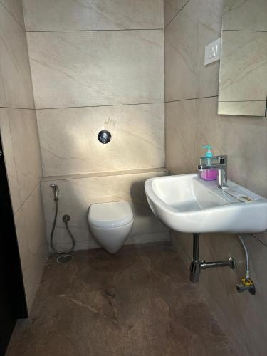 a bathroom with a sink and a toilet at Sunny Executive in Satara