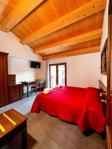 a bedroom with a red bed and a table at Duetorri in Visso