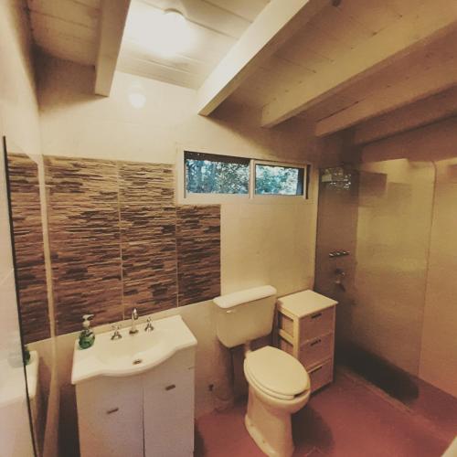 a bathroom with a toilet and a sink at Miralrio in Santa Rosa de Calamuchita