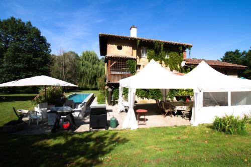 a backyard with a white tent and a house at Le moulin de Varax in Saint-Paul-de-Varax