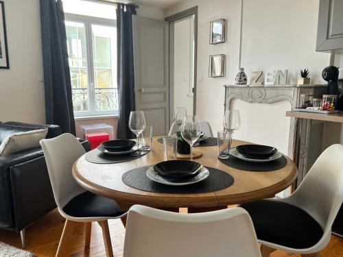 une salle à manger avec une table et des chaises en bois dans l'établissement Raffiné - Literie haut de gamme - Parking Gratuit - Central - WIFI rapide, à Bapaume