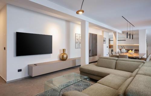 Una sala de estar con un sofá y un televisor en una pared. en Awesome Home In Salvela With Sauna, en Karpinjan
