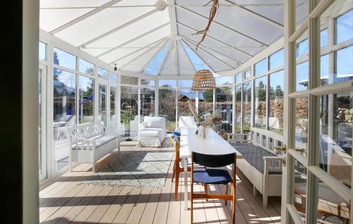 a white conservatory with a table and chairs in it at 3 Bedroom Stunning Home In Hundested in Hundested