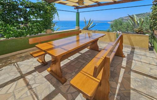un tavolo di legno e panche su un patio di Stunning Home In Razanj a Ražanj