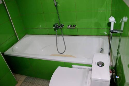 a green and white bath tub with a shower at Matcheu Palace Hôtel in Djoungolo