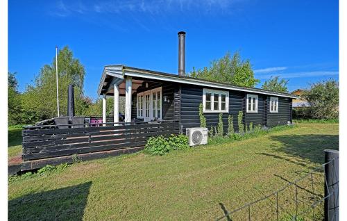 a small wooden house on a grassy field at Lovely Home In Holbæk With Wifi in Holbæk