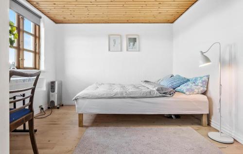 a bed in a room with a wooden ceiling at 4 Bedroom Gorgeous Home In Nørre Alslev in Nørre Alslev