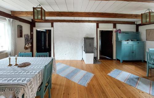 a living room with a table and a kitchen at Amazing Home In Örkeljunga With Sauna in Orkelljunga