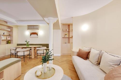 un salon avec un canapé et une table dans l'établissement ONIRI - Serviced Apartment in Place Vendôme, à Paris