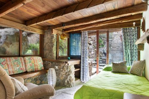 a bedroom with a green bed in a room with windows at Finca el pilar in La Guancha