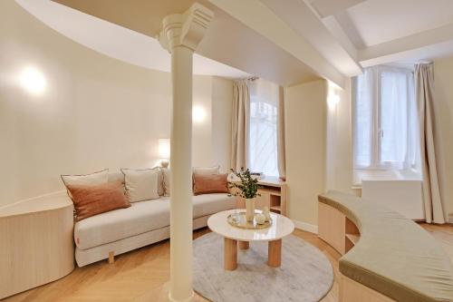 un salon avec un canapé et une table dans l'établissement ONIRI - Serviced Apartment in Place Vendôme, à Paris