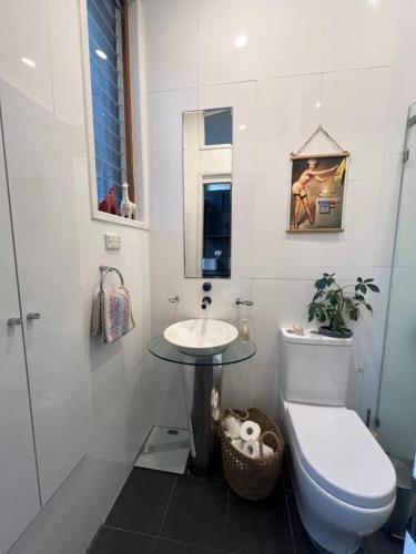 a white bathroom with a toilet and a sink at Casa Portuguesa in Sydney