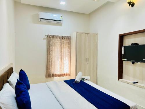 a bedroom with a bed and a tv in it at Agariya Pool Villa near Lake pichola in Udaipur