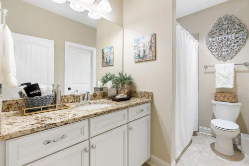 a bathroom with a sink and a toilet and a mirror at Comfort & Convenience Near Auburn University in Auburn