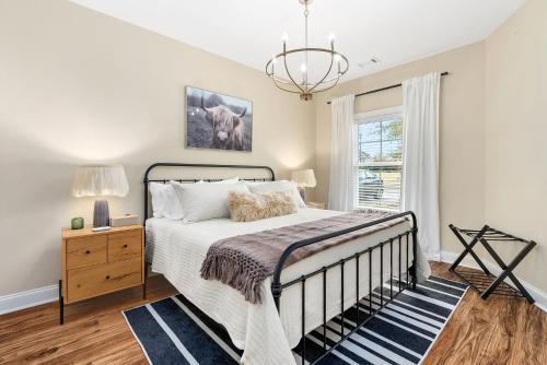 a bedroom with a bed and a chandelier at Comfort & Convenience Near Auburn University in Auburn