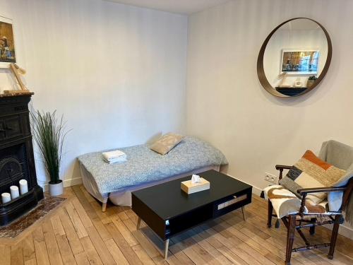 une chambre avec un lit, une table et un miroir dans l'établissement Rare appartement d'architecte en haut de Montmartre, à Paris