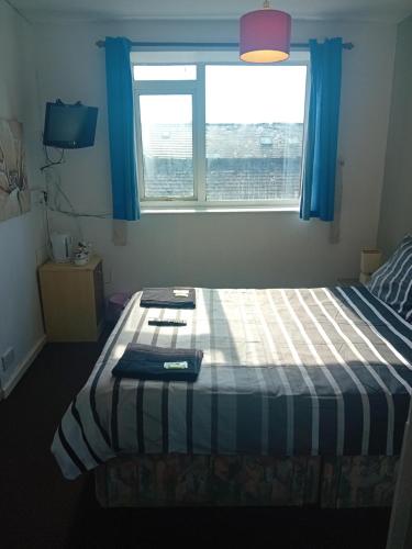 a small bedroom with a bed with a window at MyRoomz New Discovery Hotel in Blackpool