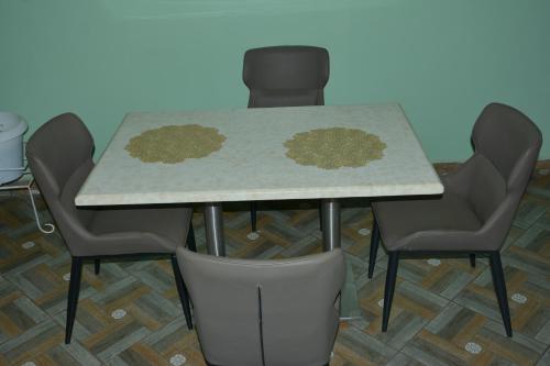 a dining room table with chairs and a counter top at Pal Furnished Houses in Bulenga
