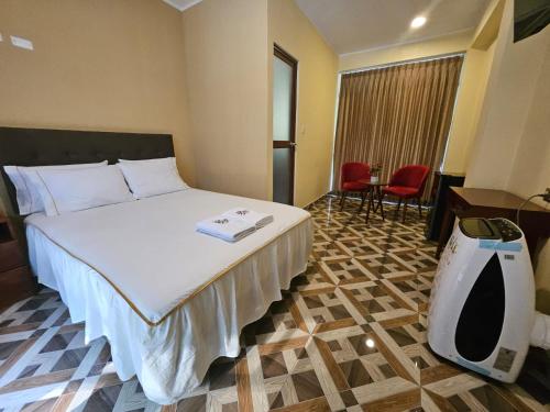 a hotel room with a bed and a desk and chairs at LEMBRANÇAS HOTEL LODGE in Tingo María