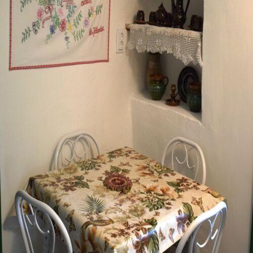 a table with a flowered table cloth on it in a room at Póra Vendégház in Magyaregregy