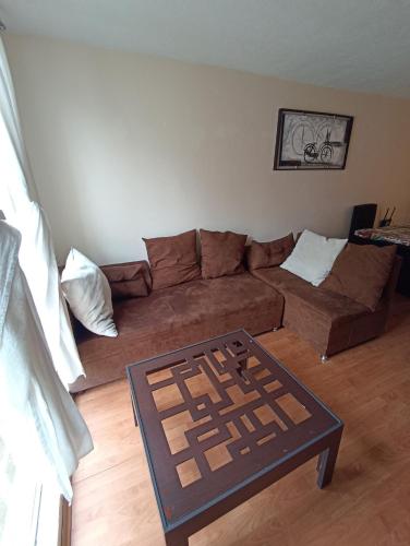 a living room with a brown couch and a table at A 10 min del zócalo!! Casa de 2 plantas in Atlixco