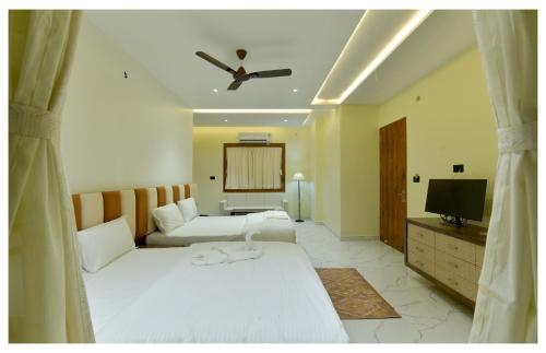 a hotel room with two beds and a television at Yashvrinda in Mandor