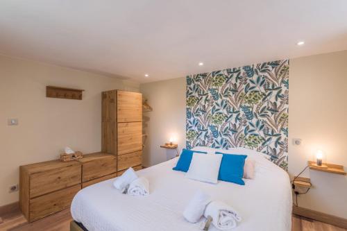 une chambre avec un grand lit blanc avec des oreillers bleus dans l'établissement Appartement Couttet - Welkeys, à Chamonix-Mont-Blanc