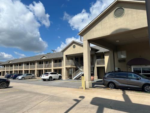 a large building with cars parked in a parking lot at Days Inn by Wyndham Wagoner in Wagoner