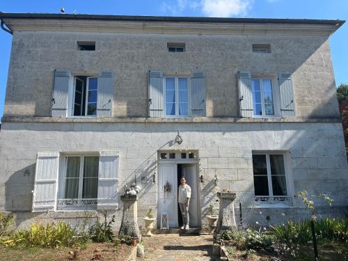 un homme debout à la porte d'une maison en pierre dans l'établissement Villa Médicis, à Brantôme