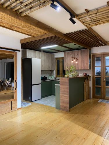 an open kitchen with green cabinets and a white refrigerator at Eco Art House in Vanadzor