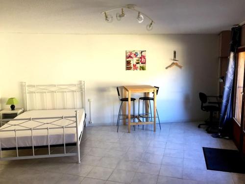 a bedroom with a bed and a table and chairs at Le Meix Claude Bulland maison de vigneron in Vergisson