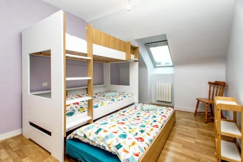 - une chambre avec des lits superposés et une table dans l'établissement Rêves de marins T3 avec parking privé en hyper centre, à Roscoff